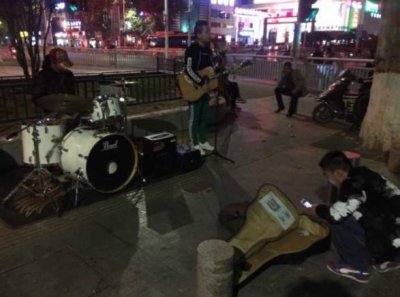 ​郑州歌手街头唱《关于郑州的记忆》 过往行人微信扫码打赏